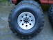 1979 Ford Bronco - Close-up of a red vehicle's large off-road tires and silver rims.