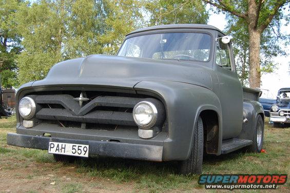Gray 1953 Ford F-series truck with a custom hood, parked on grass