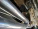 1996 Ford Bronco - Underside view of a vehicle's suspension system, showing metal bars and bolted components.