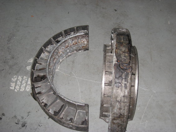 Broken turbine housing, split into two pieces, showing internal blades and damage