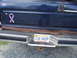 1989 Ford Bronco - Rear view of a 1989 Ford Bronco showing the bumper, license plate, and a decorative ribbon sticker.