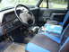 1989 Ford Bronco - The interior of a truck shows the dashboard, steering wheel, and a shop manual on the passenger seat.