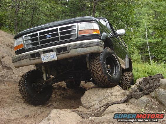 Black 1995 Ford Bronco climbing rocks on a trail