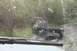 1990 Chevrolet Suburban - A black SUV navigates a muddy trail, its rear end partially submerged in thick mud.