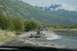 1990 Chevrolet Suburban - SUV and trailer navigating a water crossing with a scenic mountain backdrop.