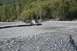 1990 Chevrolet Suburban - A four-wheel-drive vehicle navigates a rocky riverbed, pulling a small trailer.