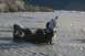 1990 Chevrolet Suburban - Two individuals work to recover an overturned ATV from a rocky, shallow riverbed.