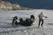1990 Chevrolet Suburban - Two individuals work to recover an overturned ATV from a shallow, rocky riverbed.