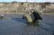 1990 Chevrolet Suburban - A utility vehicle is being towed from a riverbed by a truck.