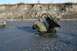 1990 Chevrolet Suburban - Two vehicles are stuck in a muddy riverbed, one is an off-road utility vehicle and the other a pickup truck.