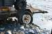 1990 Chevrolet Suburban - A trailer sits on a rocky shore with a flat tire, partially submerged in shallow water.