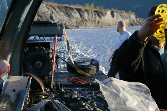 Polaris Ranger ATV on trailer, side view, with a person holding a yellow hose