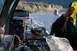 1990 Chevrolet Suburban - A Polaris Ranger ATV is loaded onto a trailer by a rocky riverbank, with two people present.