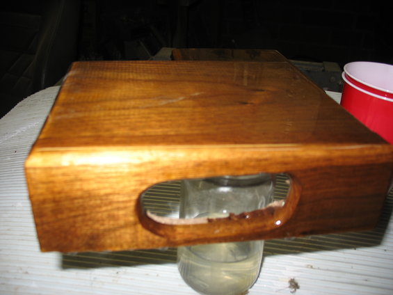 Wooden tray with cutout handles, resting on a jar