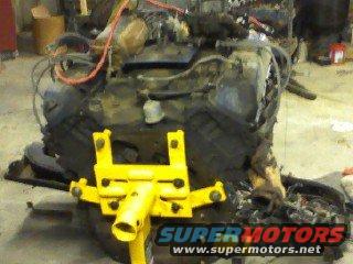Engine block on a yellow stand in a garage