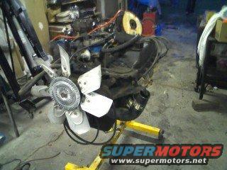Engine on yellow stand, Supermotors logo visible