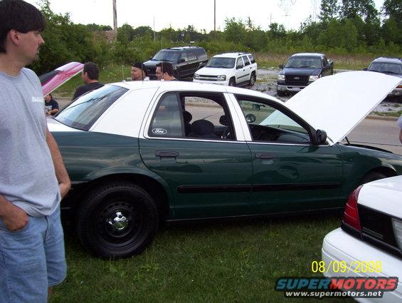 Green and white sedan, hood open. Date stamp 08/09/2008