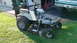 1979 Ford Bronco - A Dixie Chopper zero-turn mower with large rear tires is shown on a lawn next to a building and a pickup truck.