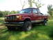 1984 Ford Bronco II - This red pickup truck features a lifted suspension and aftermarket wheels, suggesting off-road modifications.
