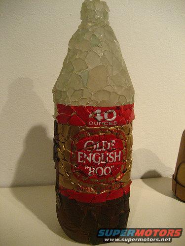 bottle covered in glass shards with 'Olde English 800' label