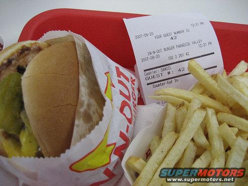 In-N-Out Burger meal on a red tray, showing a burger in wrapper and a container of fries next to a receipt