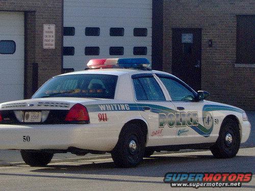 Whiting police car with "POLICE" and "911" markings, side view
