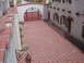 2001 Ford Mustang - A courtyard with a red gate and a building Spanish architectural elements.