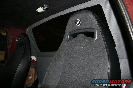 Interior view of bucket seats with a logo on the headrest
