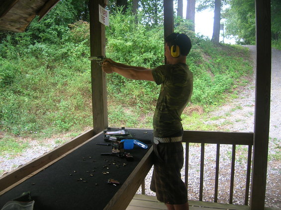 Person at shooting range aiming a handgun