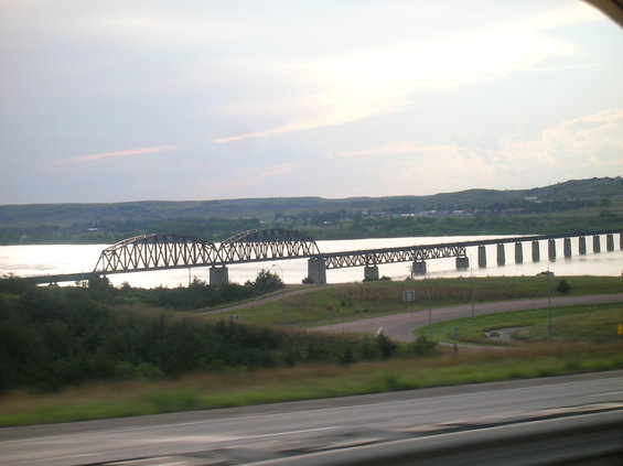 Bridge over a wide river with hills in the background