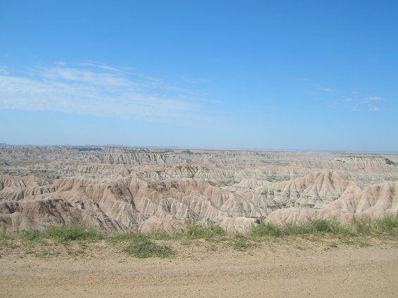 Badlands landscape with eroded hills under a blue sky