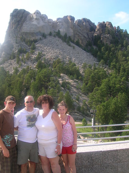 Family poses in front of Mount Rushmore