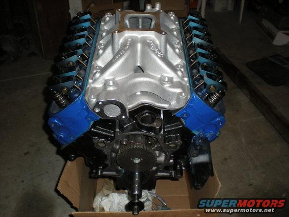 V8 engine with blue valve covers and silver intake manifold, sitting in a cardboard box