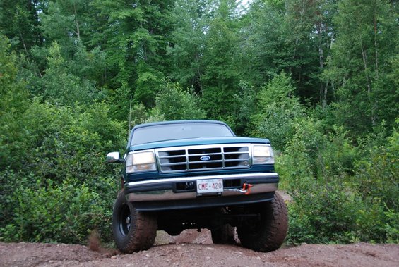 Green 1996 Ford Bronco front view on dirt road