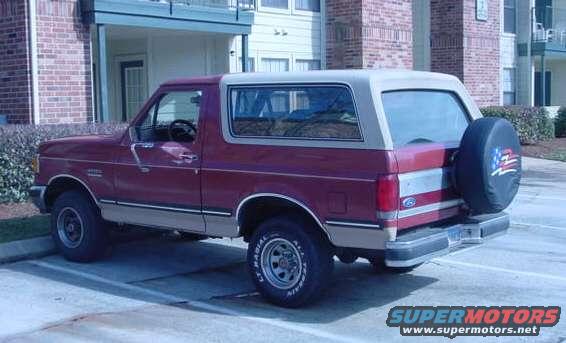 Maroon and tan 1987 Ford Bronco, rear quarter view with spare tire