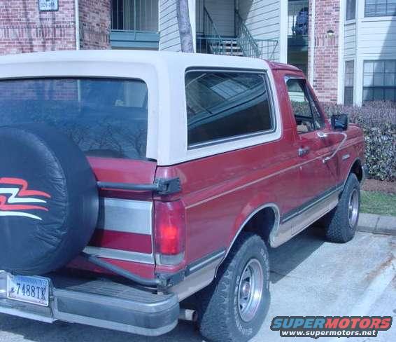 1987 Ford Bronco, rear view, red with white top, spare tire on swing away carrier