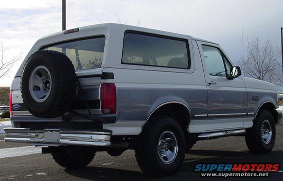 Rear quarter view of a white and gray 1995 Ford Bronco with a spare tire mounted on the back