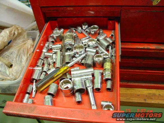 Open red toolbox drawer filled with sockets and wrenches