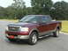 2005 Ford F-150 - This maroon and tan Ford F-150 pickup truck is shown from a three-quarter front view, parked outdoors.