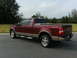 2005 Ford F-150 - This maroon and tan Ford F-150 pickup truck is viewed from a 3/4 rear angle.