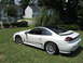 1992 Dodge Stealth - A white 1992 Dodge Stealth RT/TT is parked on a grassy lawn in front of residential buildings.