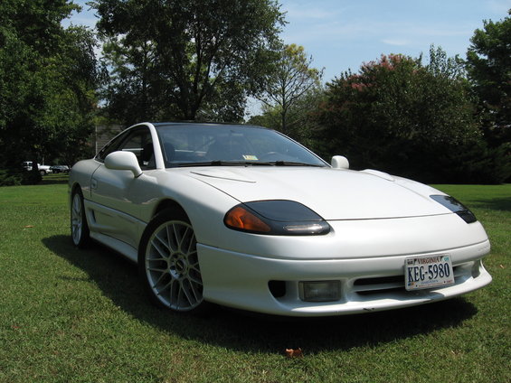 White 1992 Dodge Stealth sports car with black hood accents and multi-spoke wheels parked on grass