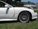 1992 Dodge Stealth - A white sports car with aftermarket wheels and 'TWIN TURBO' badging is parked on grass.