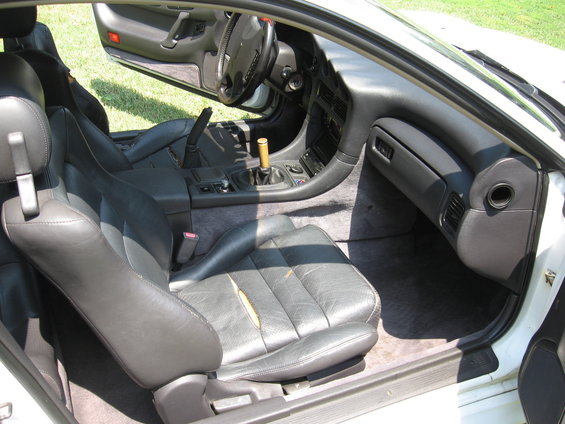 Interior of a 1992 Dodge Stealth showing worn black leather seats and dashboard