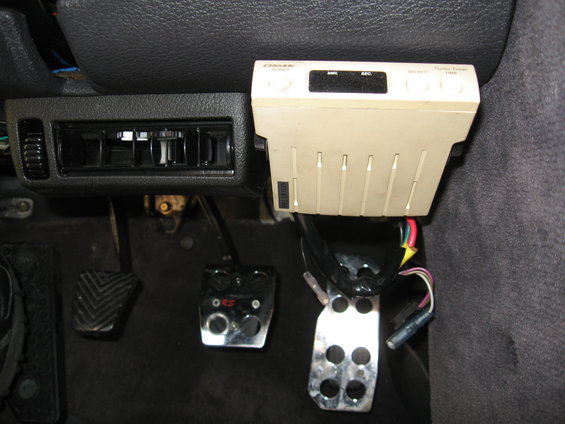 Car interior showing pedals and aftermarket climate control unit
