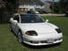1992 Dodge Stealth - The 1992 Dodge Stealth is seen from a three-quarter front view, parked on a grassy area with houses in the background.