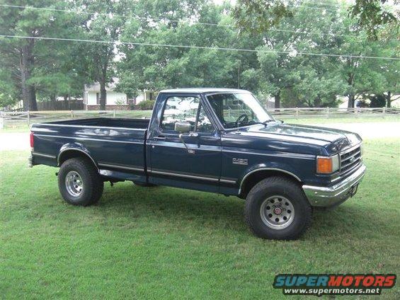 Dark blue Ford F-250 pickup truck parked on grass. It has a single cab and a long bed