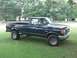 1989 Ford Bronco - A dark blue Ford F-250 pickup truck is parked on a grassy lawn with trees in the background.