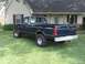 1989 Ford Bronco - This dark blue 1989 Ford F-150 pickup truck is parked in a grassy yard in front of a house.