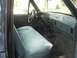 1989 Ford Bronco - The interior of a truck shows a light blue bench seat and the dashboard with a radio and gear shifter.